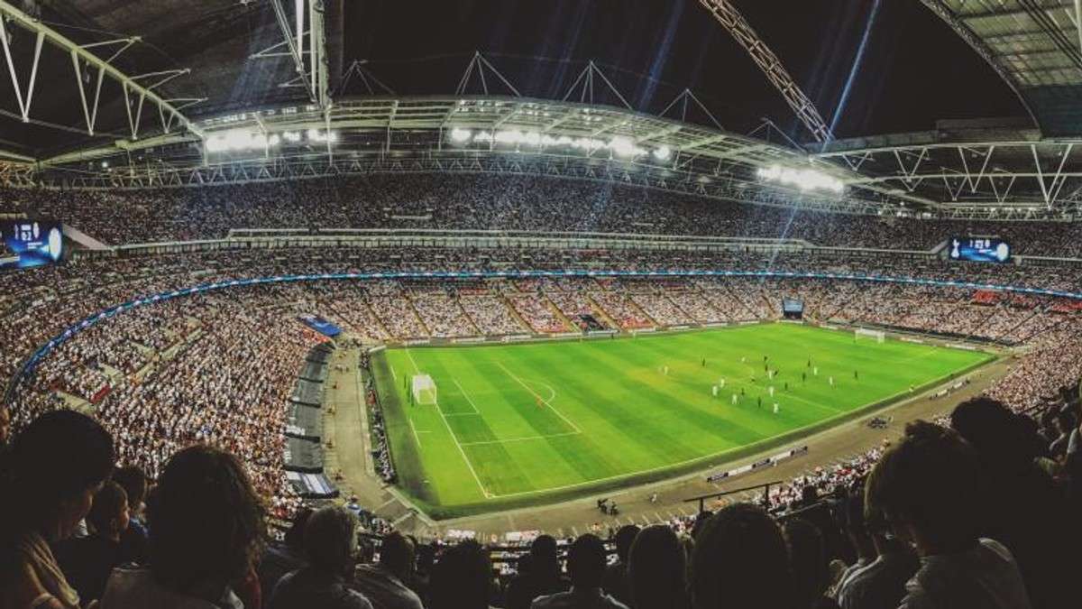 Packed stadium bowl under floodlights on matchday